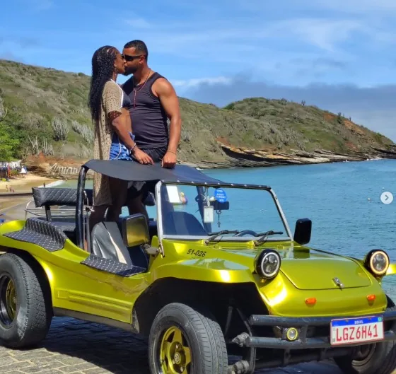 Casal sobre buggy verde próximo à praia em Búzios